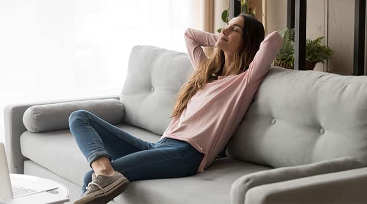 Woman relaxing on couch with lowered cortisol levels